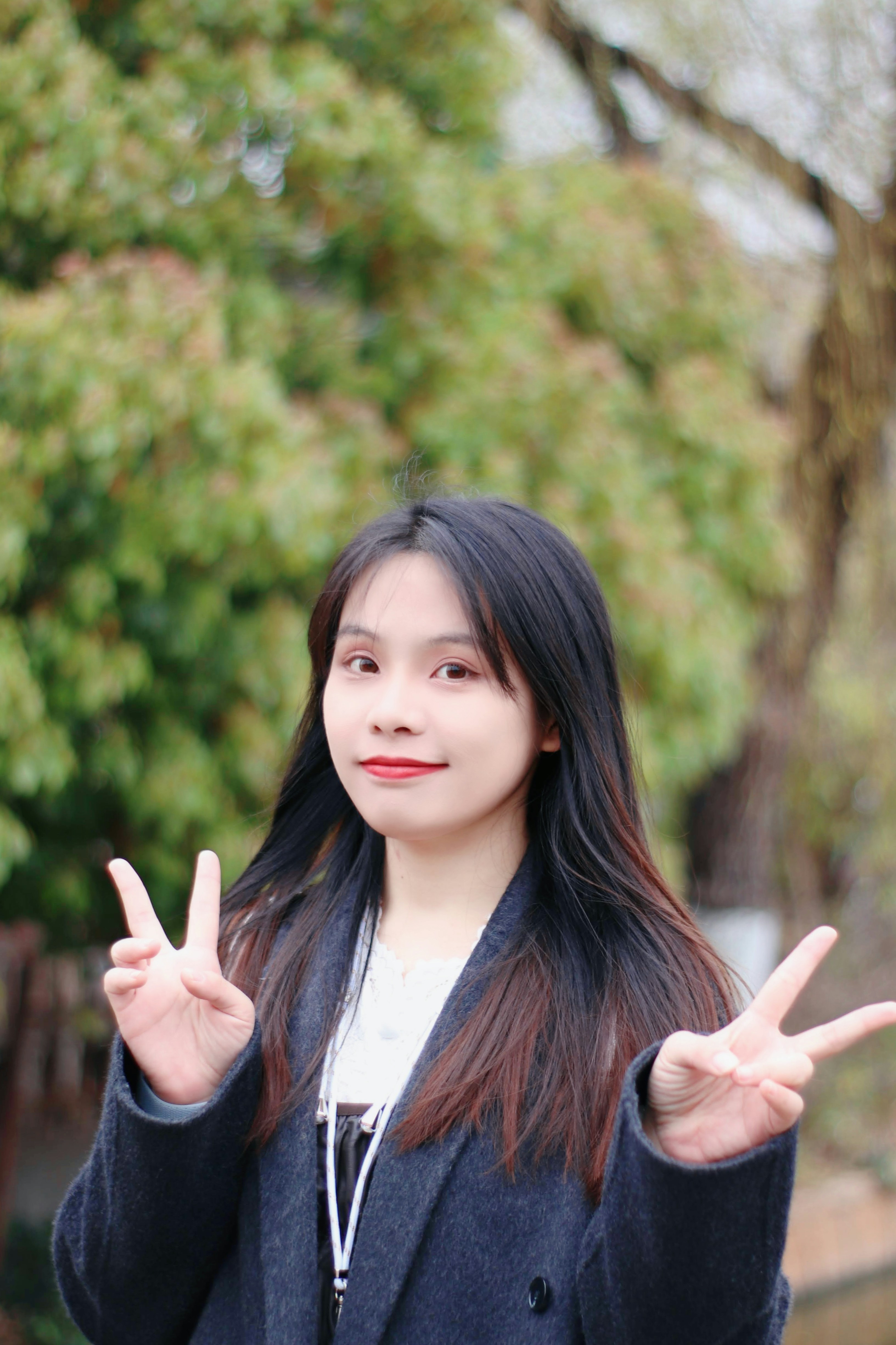 A smiling woman gives the peace sign.