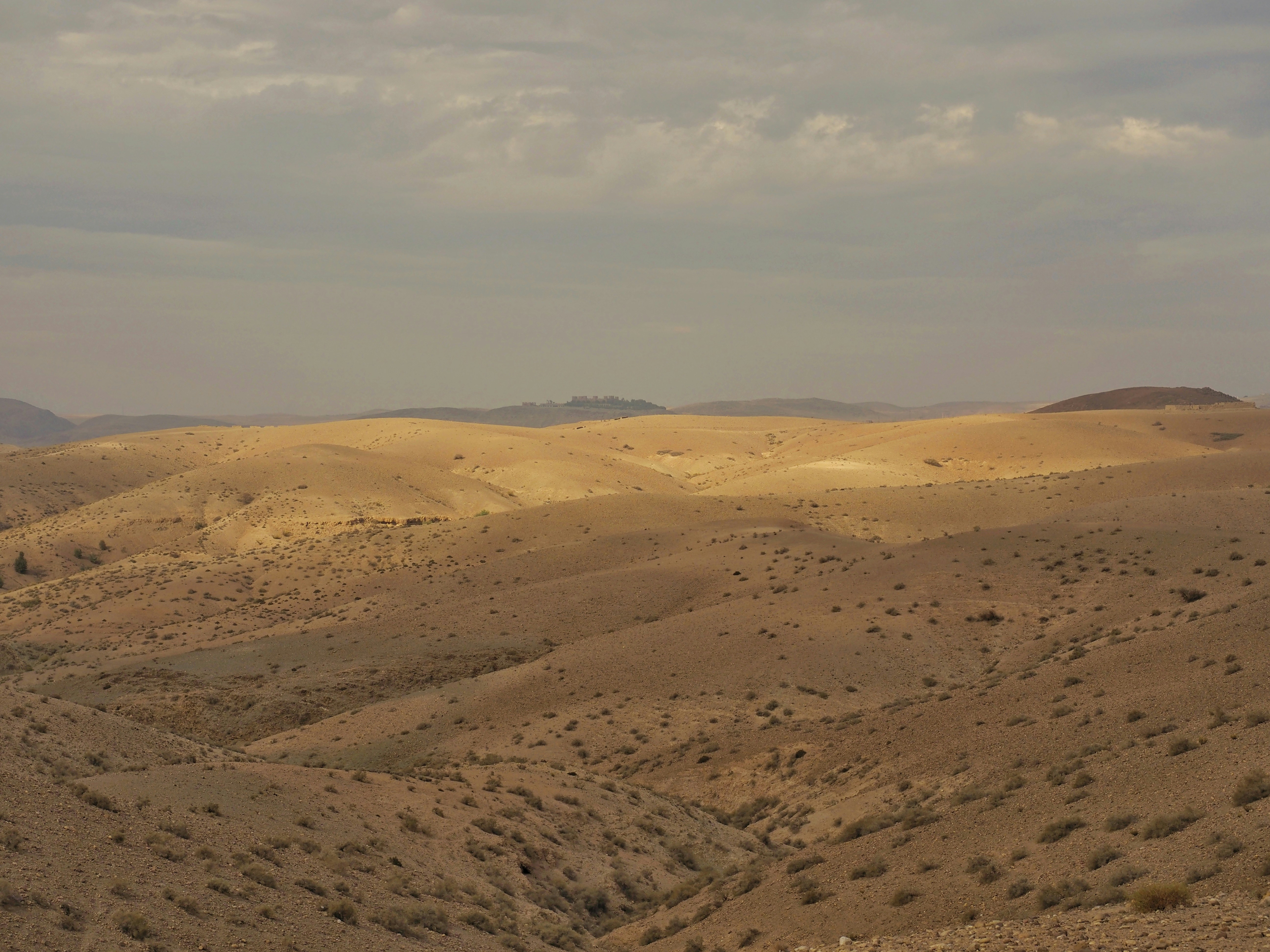 A view of a desert with a few hills in the distance
