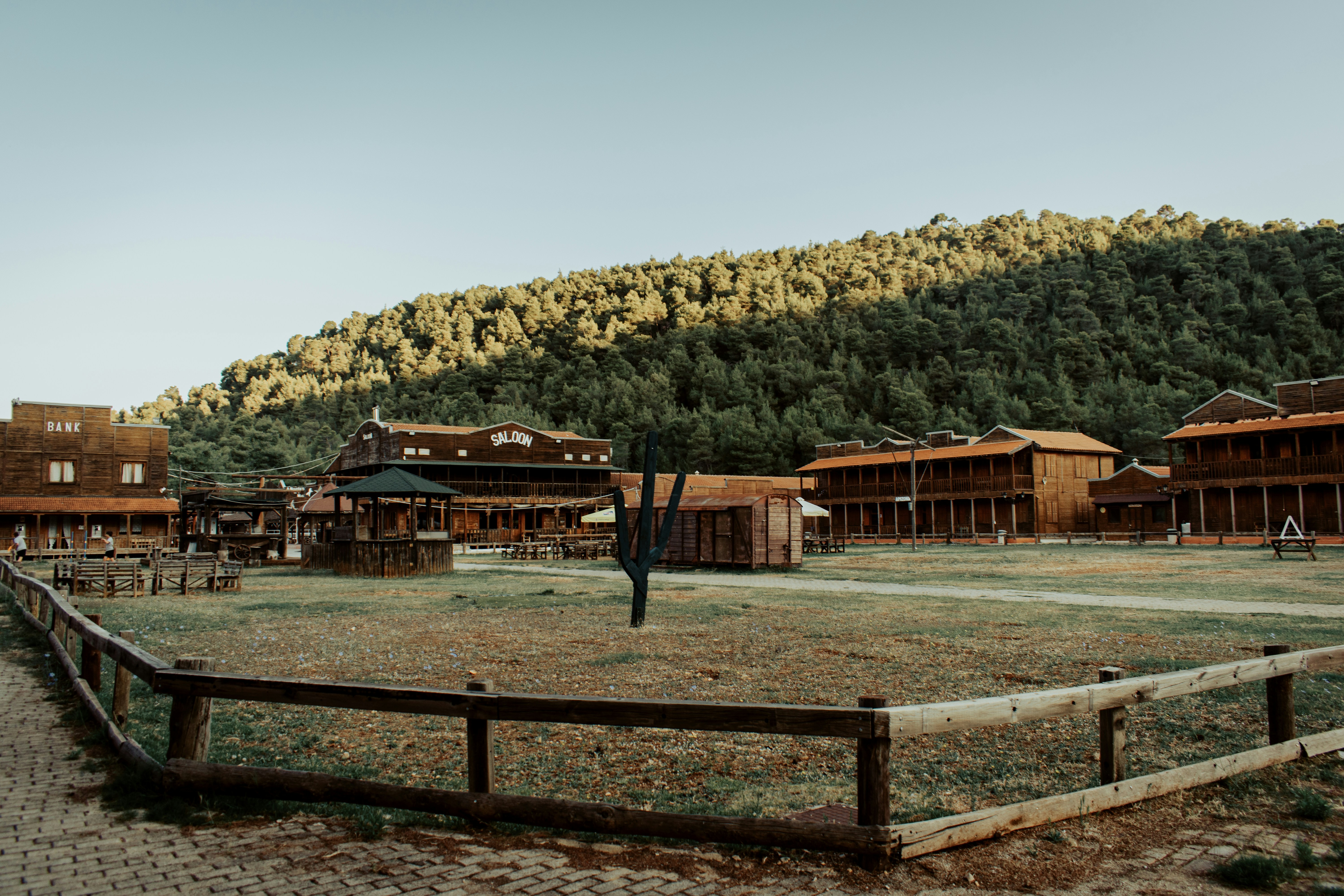 brown wooden house near green trees during daytime