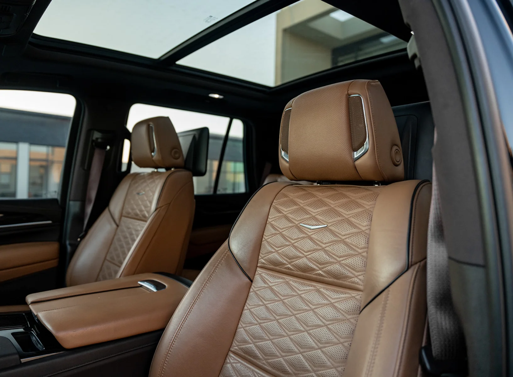 Luxury chauffeur service vehicle interior featuring plush leather seats with diamond stitching, advanced amenities, and panoramic sunroof, emphasizing comfort and elegance for discerning travelers.