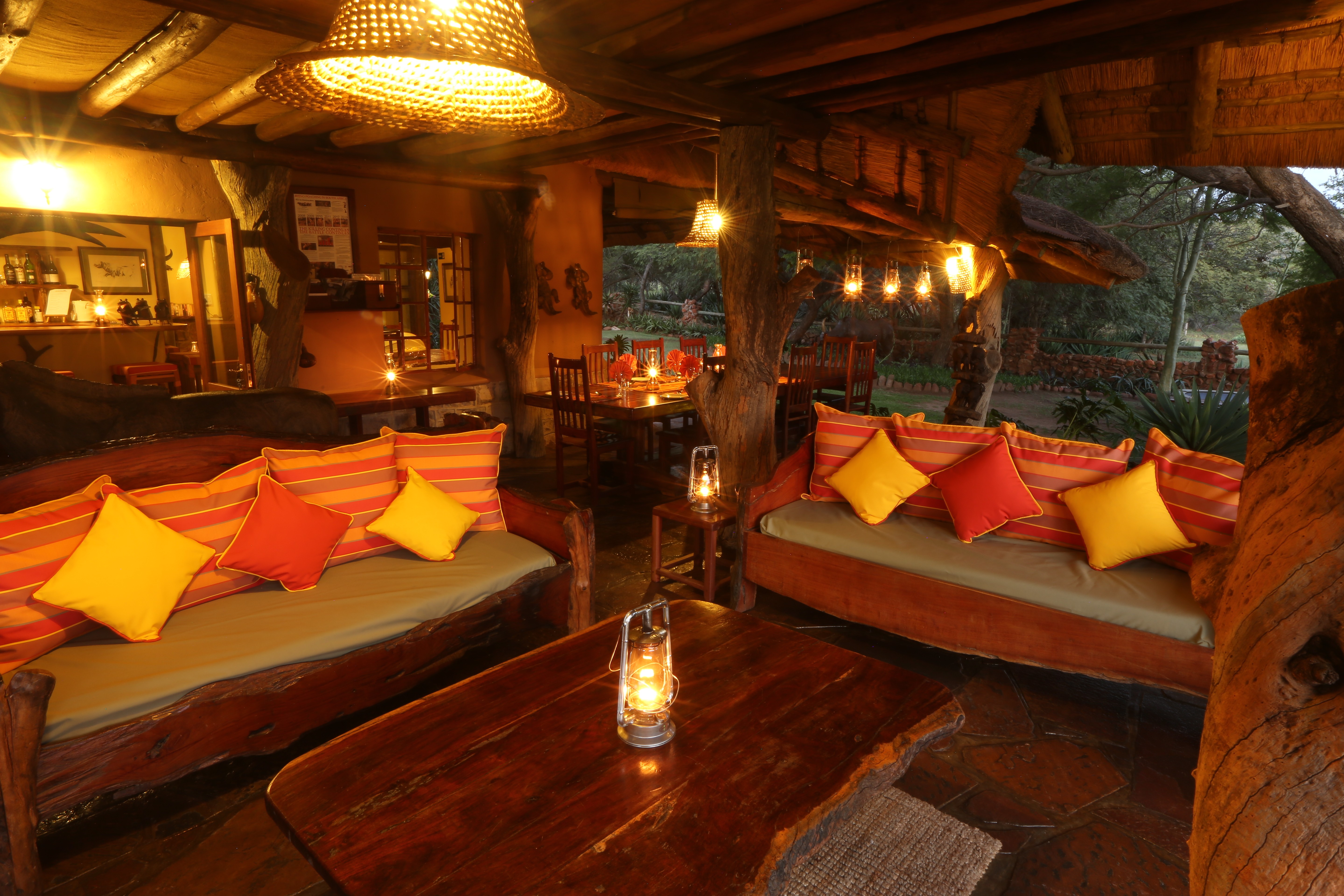 Grupp av ryttare på ridresa i Afrika galopperar över Serengetis vidsträckta slätter medan damm och gnuhjordar rör sig över horisonten under the great migration.