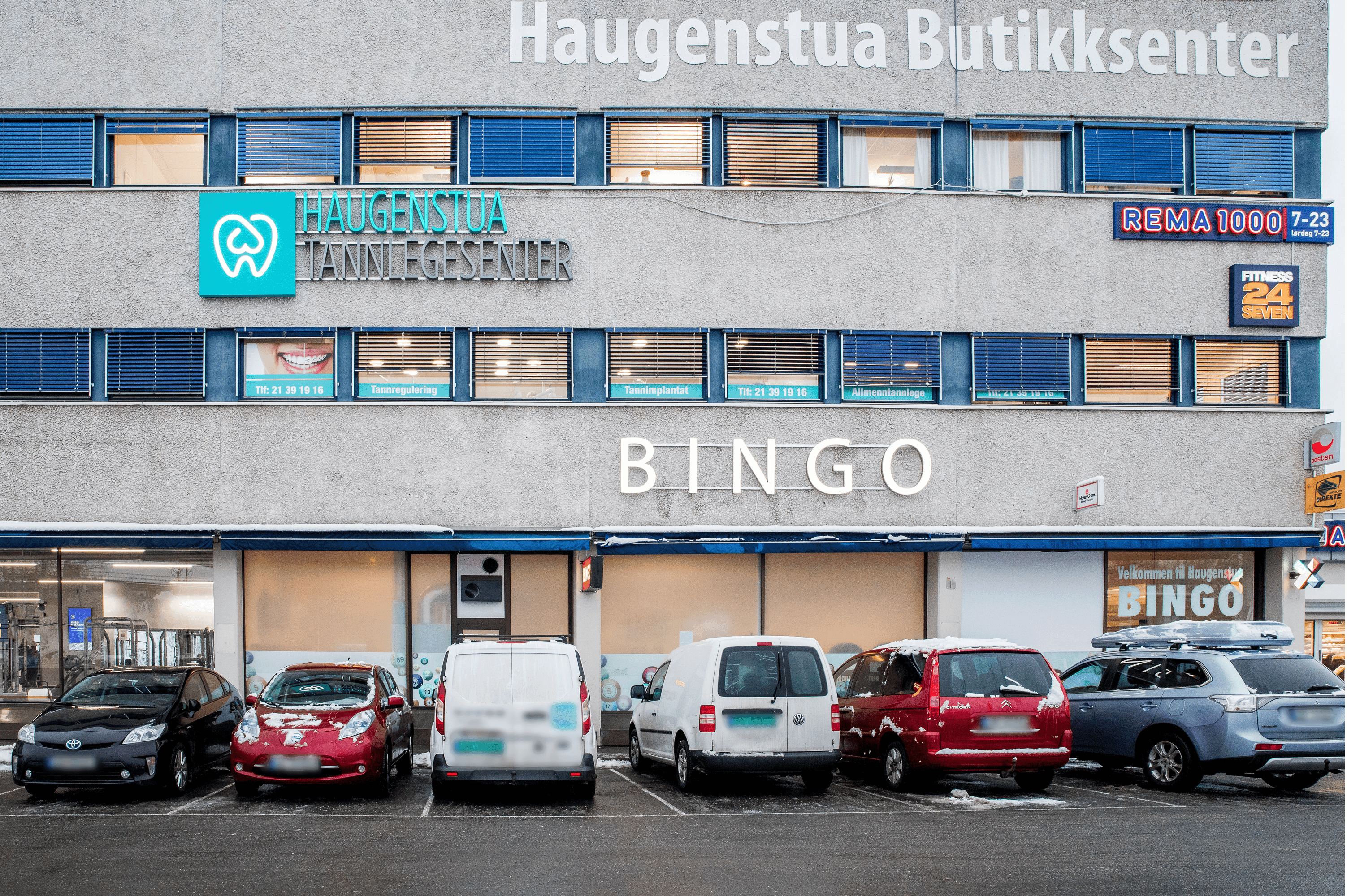 Fasaden til Haugenstua Tannlegesenter i Oslo med tydelig skilt og parkering foran klinikken.