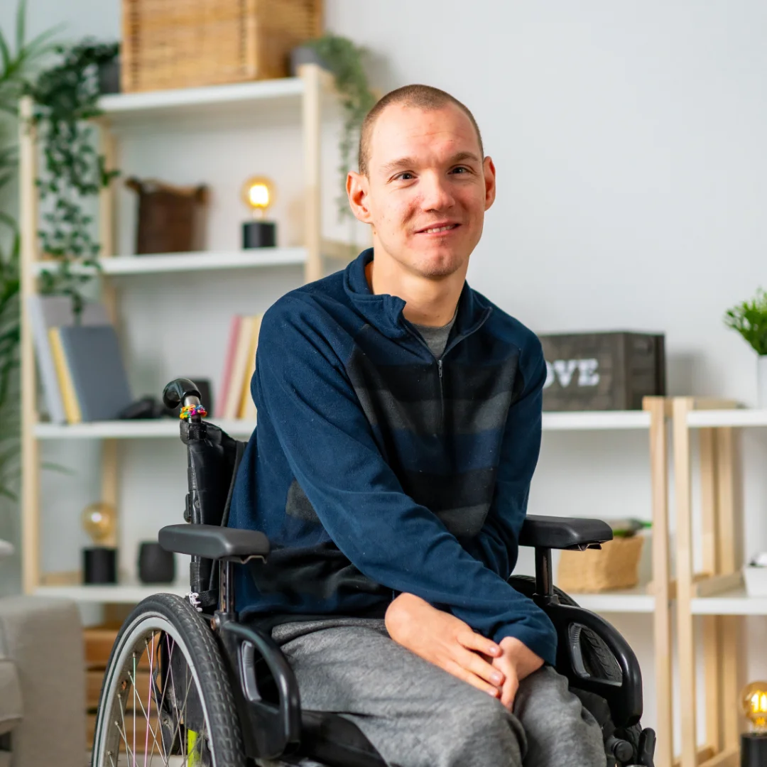 NDIS participant in wheelchair at home receiving assessment from a community nurse in Brisbane