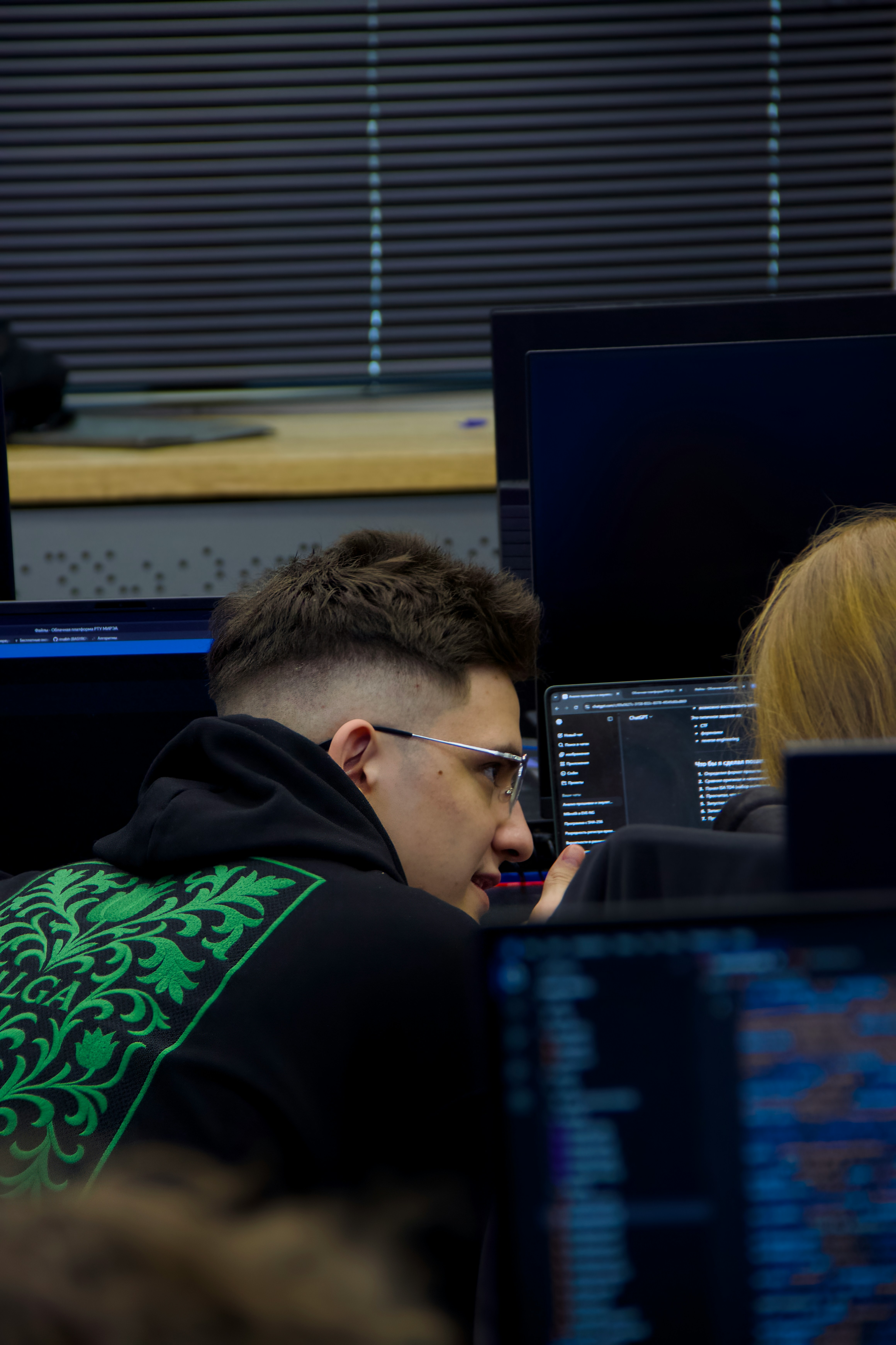Young man with glasses looking at computer screen