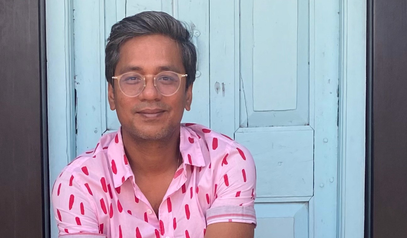 Woman working at desk with laptop and phone.