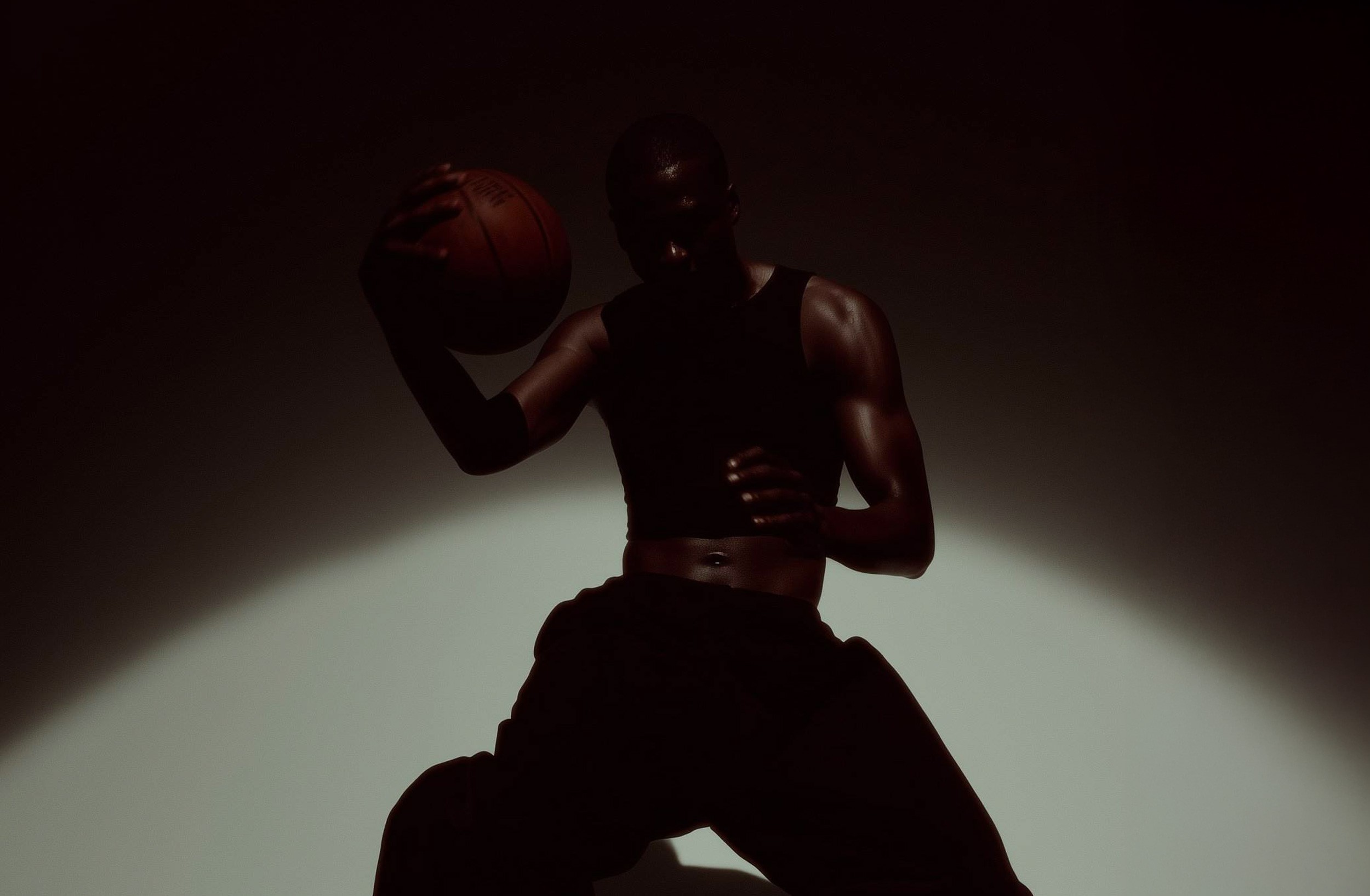 Basketball player jumping against dark background