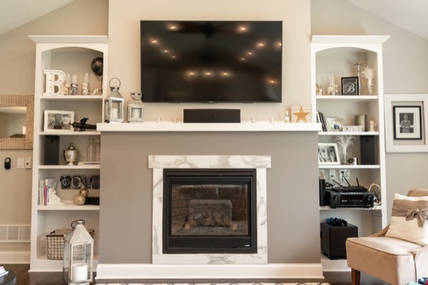 Light white grey living room with fireplace mantle and tv
