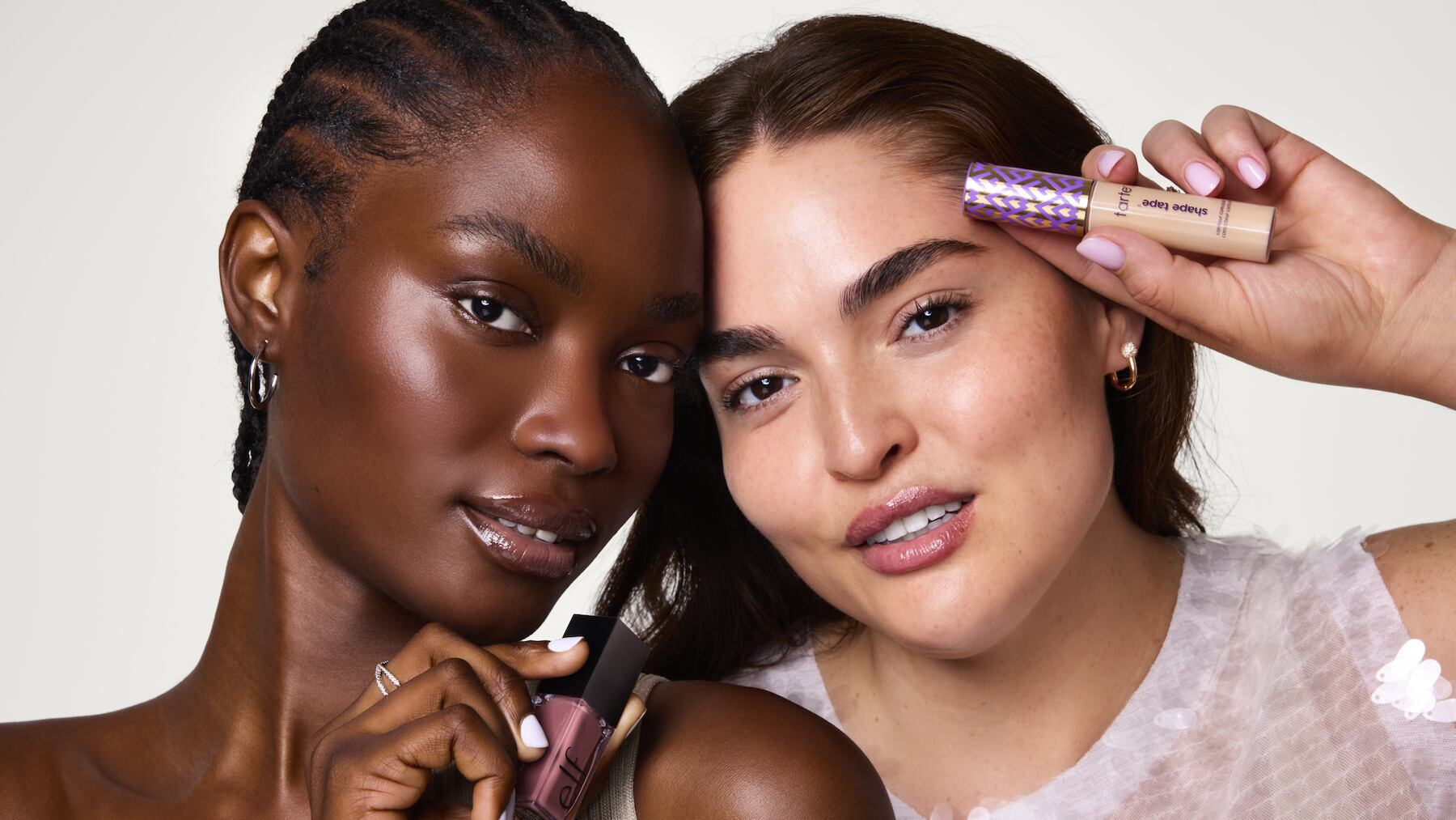 Tarte campaign image of two models holding Tarte makeup