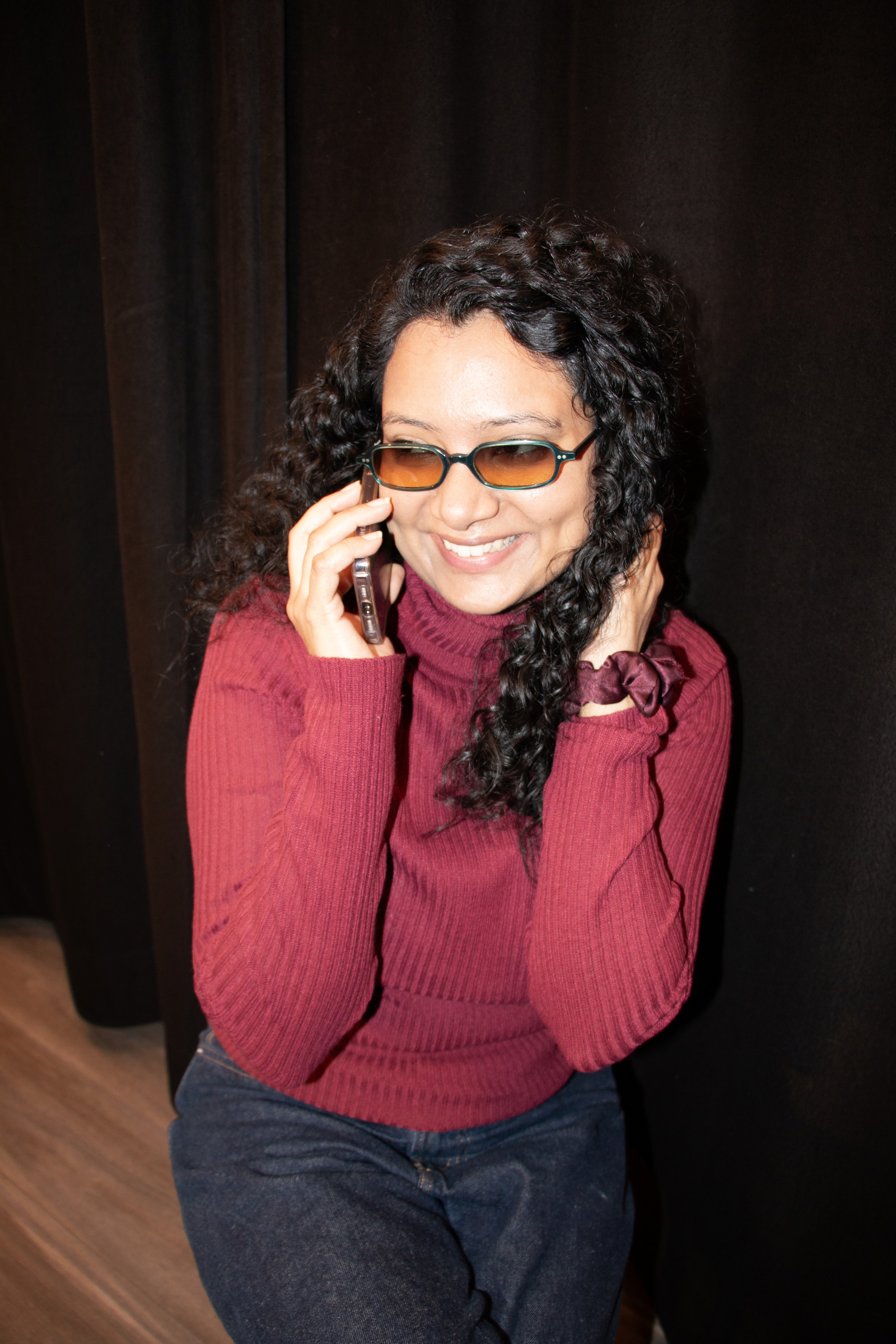 A close-up of a hand wearing multiple decorative rings against a blue background.