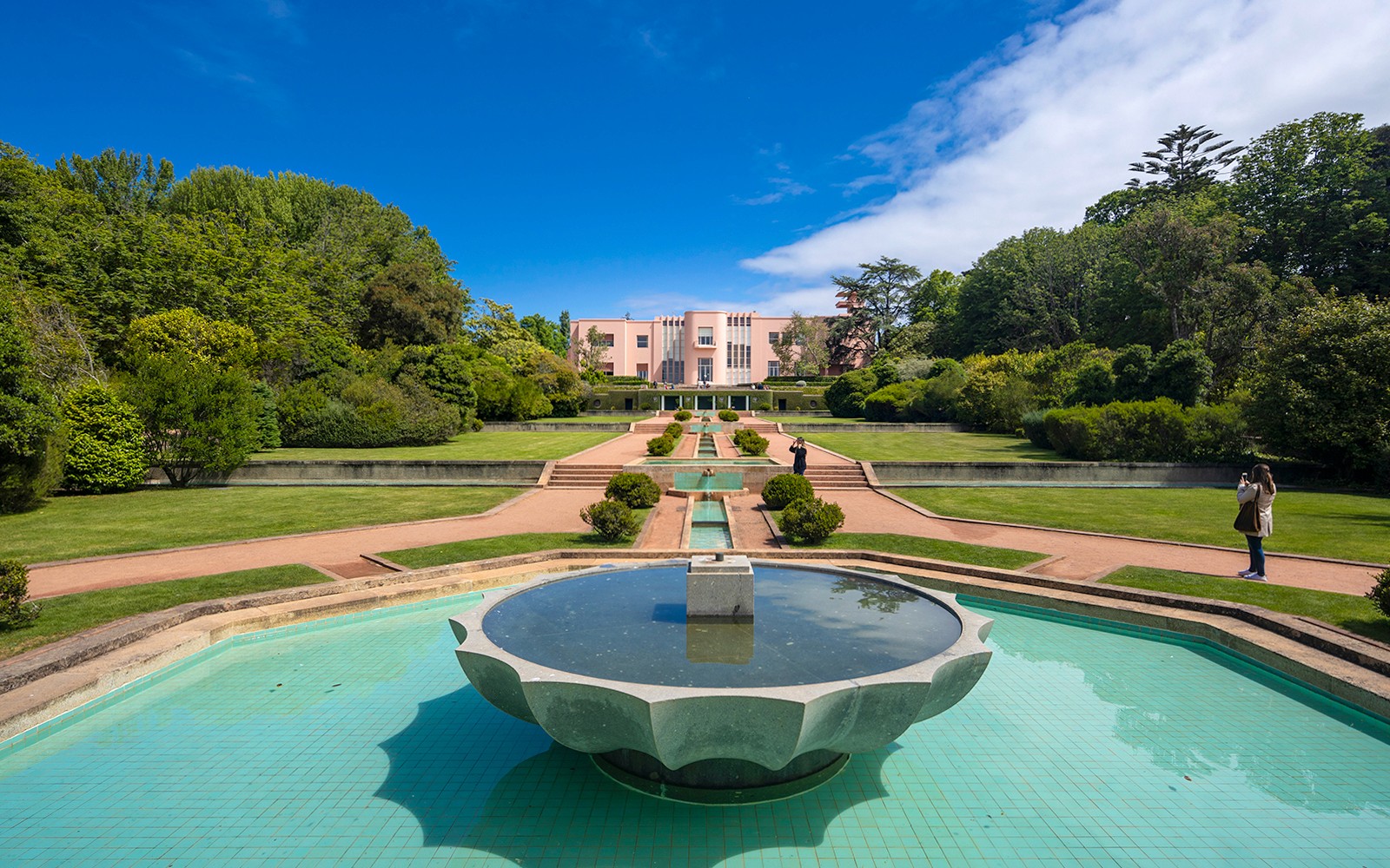 A Serralves Múzeum kertje szökőkúttal és rózsaszín Art Deco épülettel Portóban, Portugáliában.