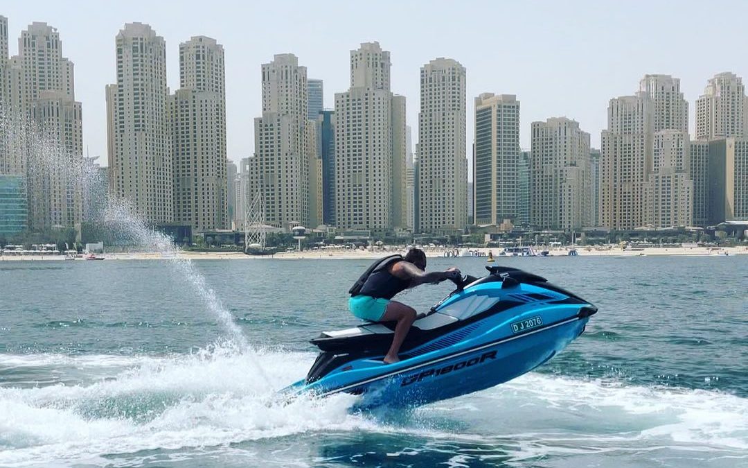 A person jet skiing near a city skyline, showcasing the benefits of jet ski for improving mind and body through engaging physical activity