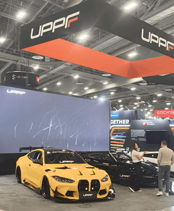30x40 SEMA booth overview with hero vehicle display, open aisle visibility, and large branded structure