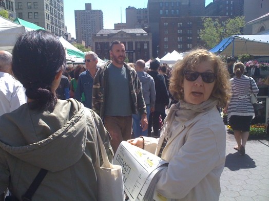A photo of a group of people distributing flyers on the street.