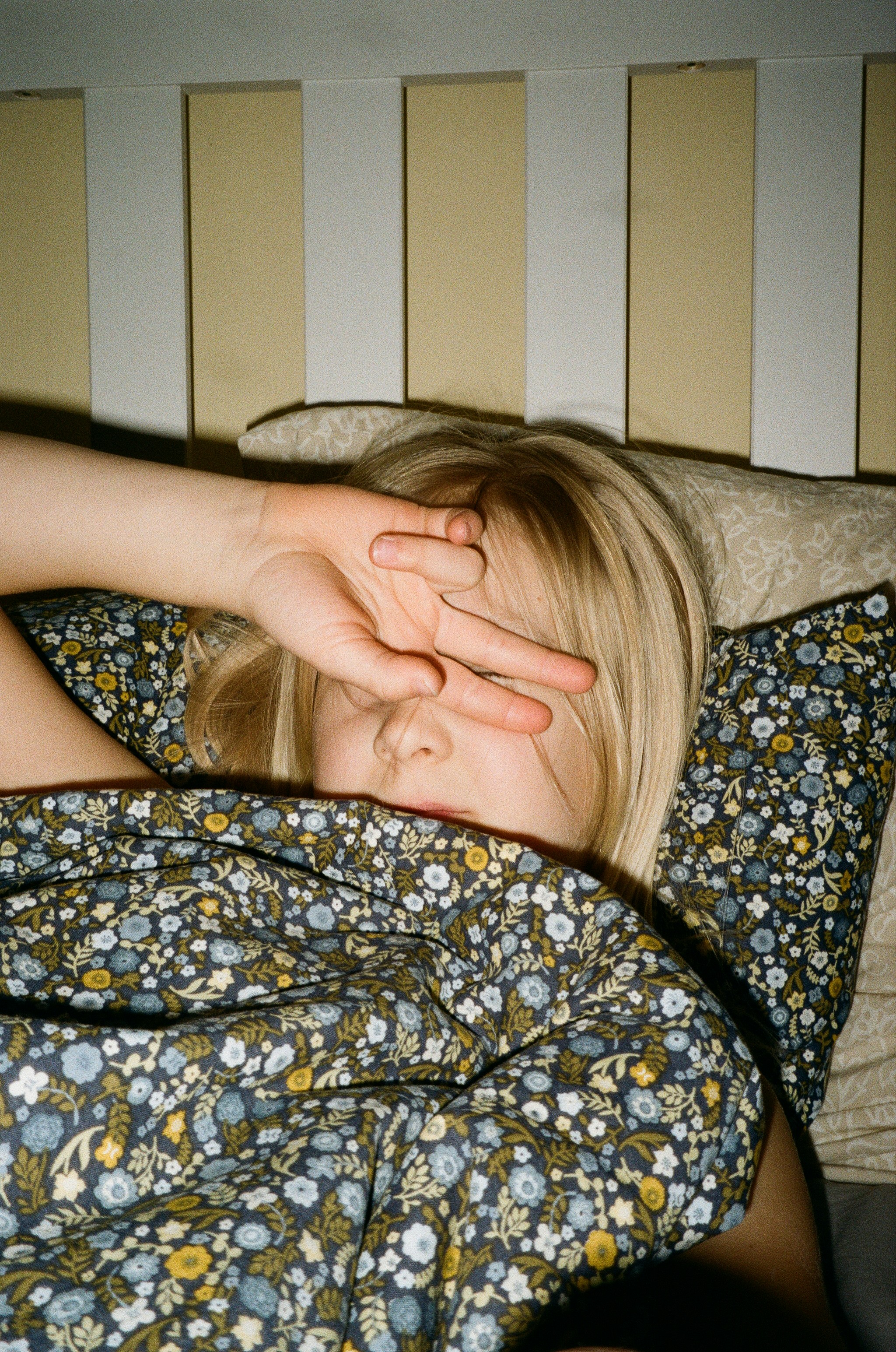 A woman laying in bed with her hand on her head