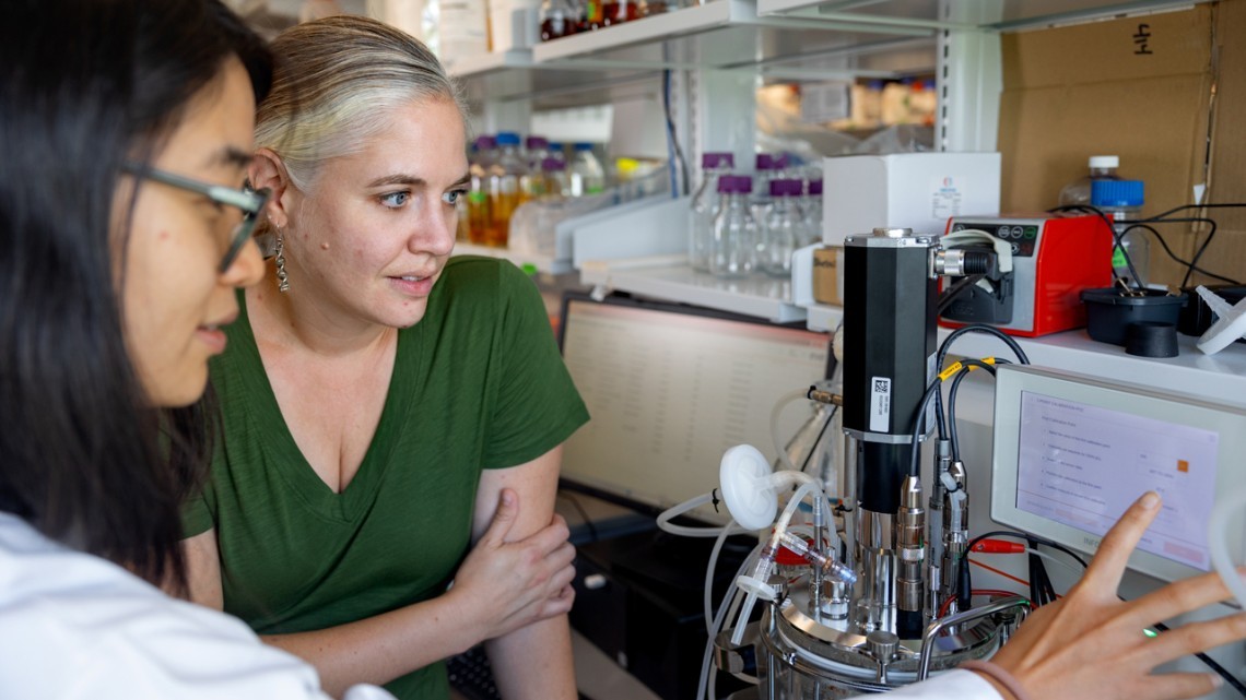 Two women in a lab observe data.