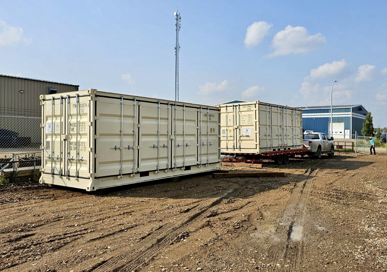 Offloading of the 20' New Open Side containers with a tilt deck trailer