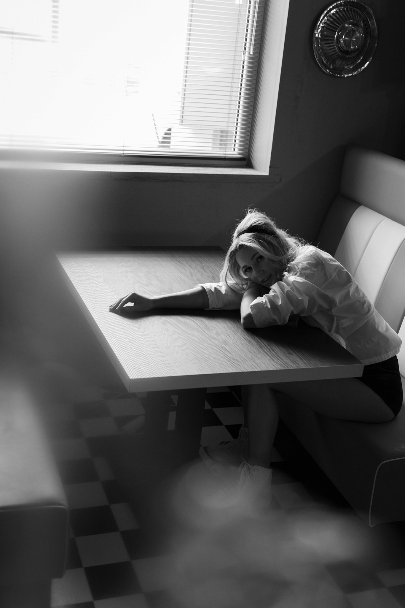 Agnieszka Czyzkowska fine art photography Warsaw woman lying on table looking at camera diner black and white