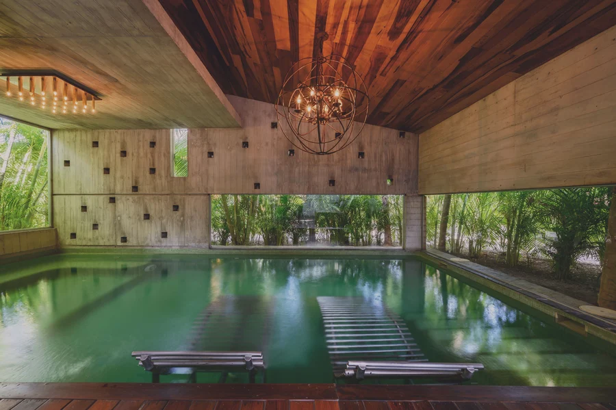 Pool area surrounded by jungle ambiance with loungers and tranquility at Be Tulum.