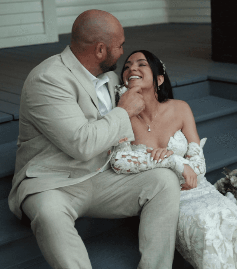 Video still of a couple newly married sitting on steps smiling