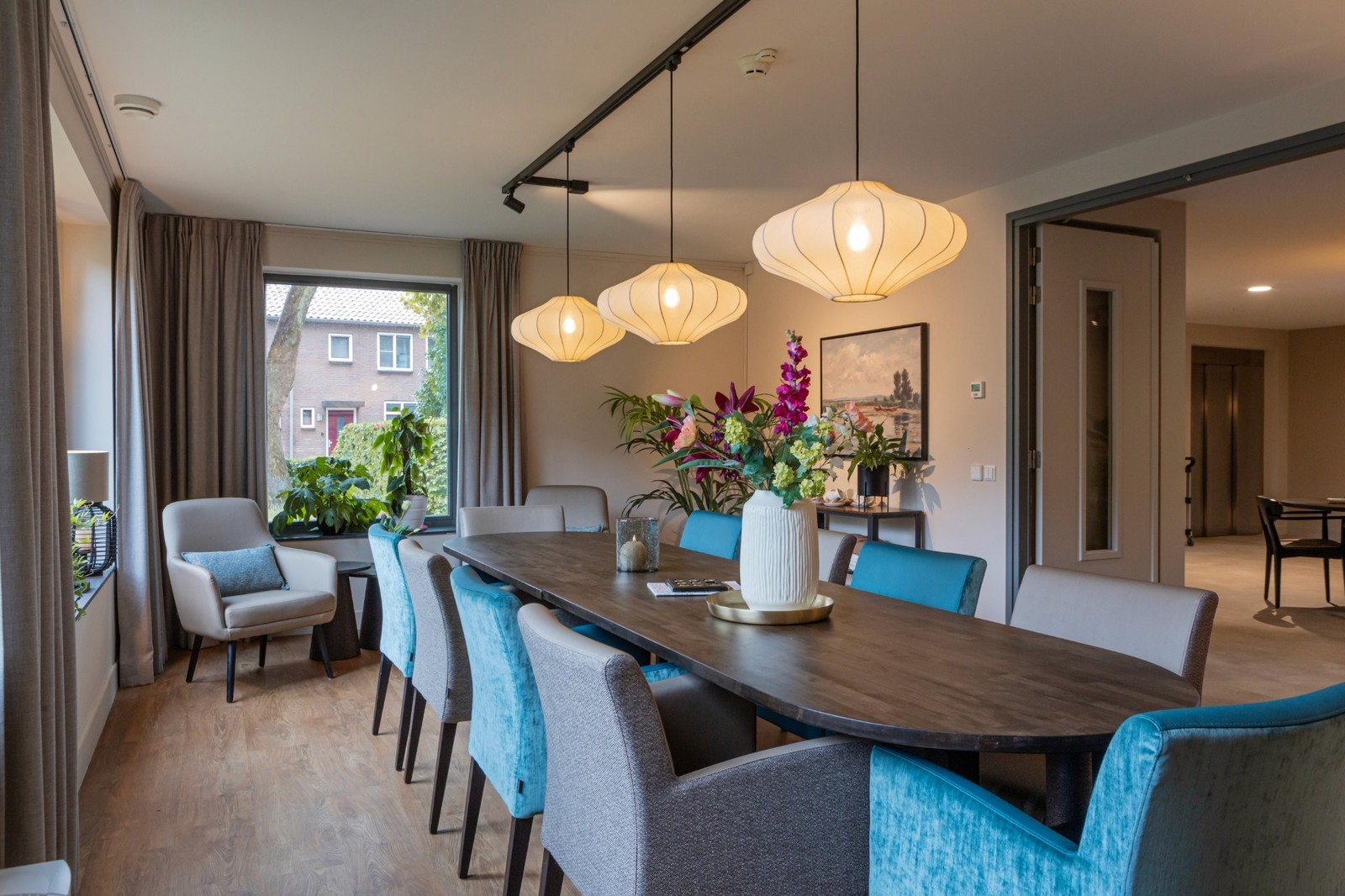 eettafel met blauwe en taupe stoelen en japandi hanglampen