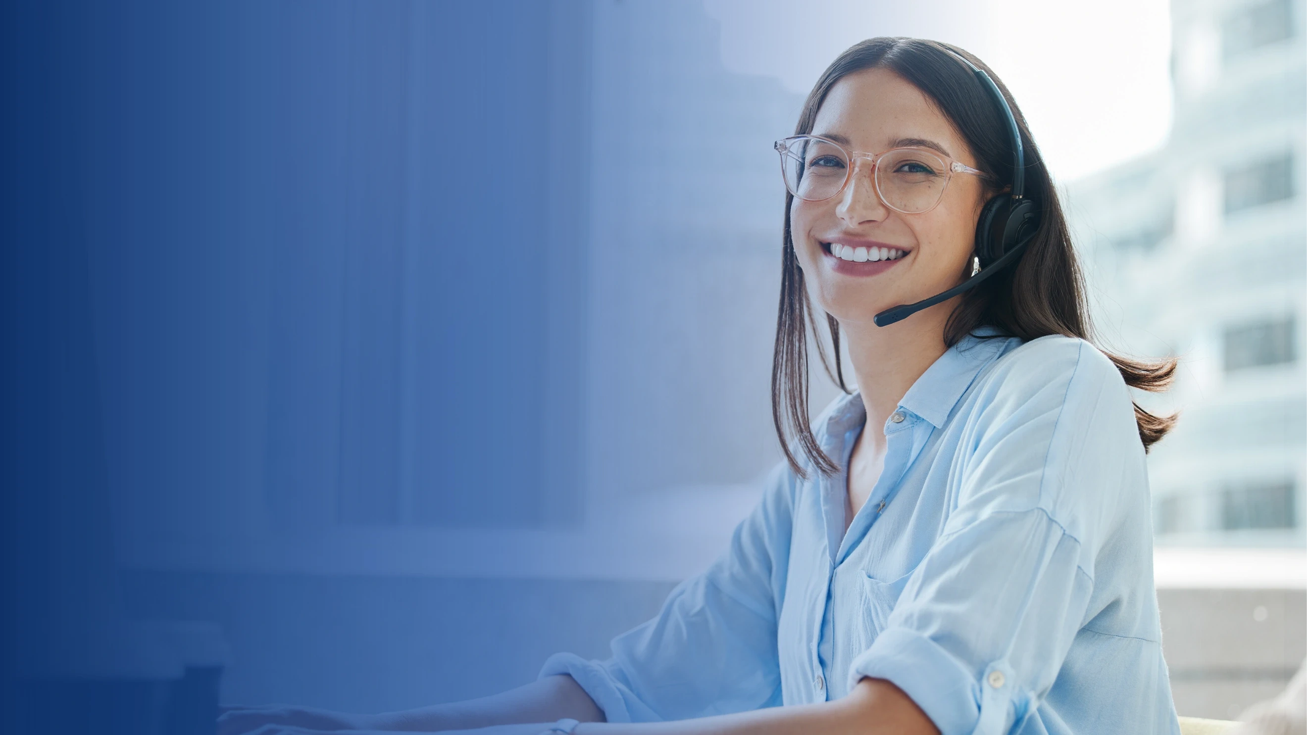 Smiling female customer service representative wearing a headset in a professional office setting