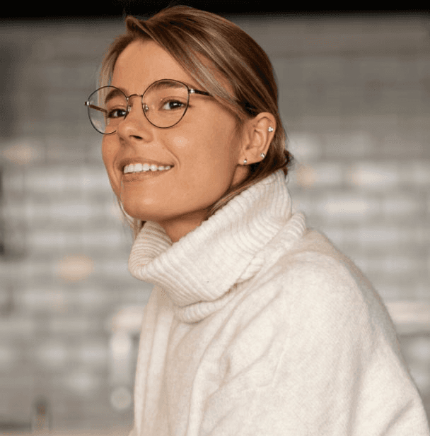 women with glasses looking sideways smilling
