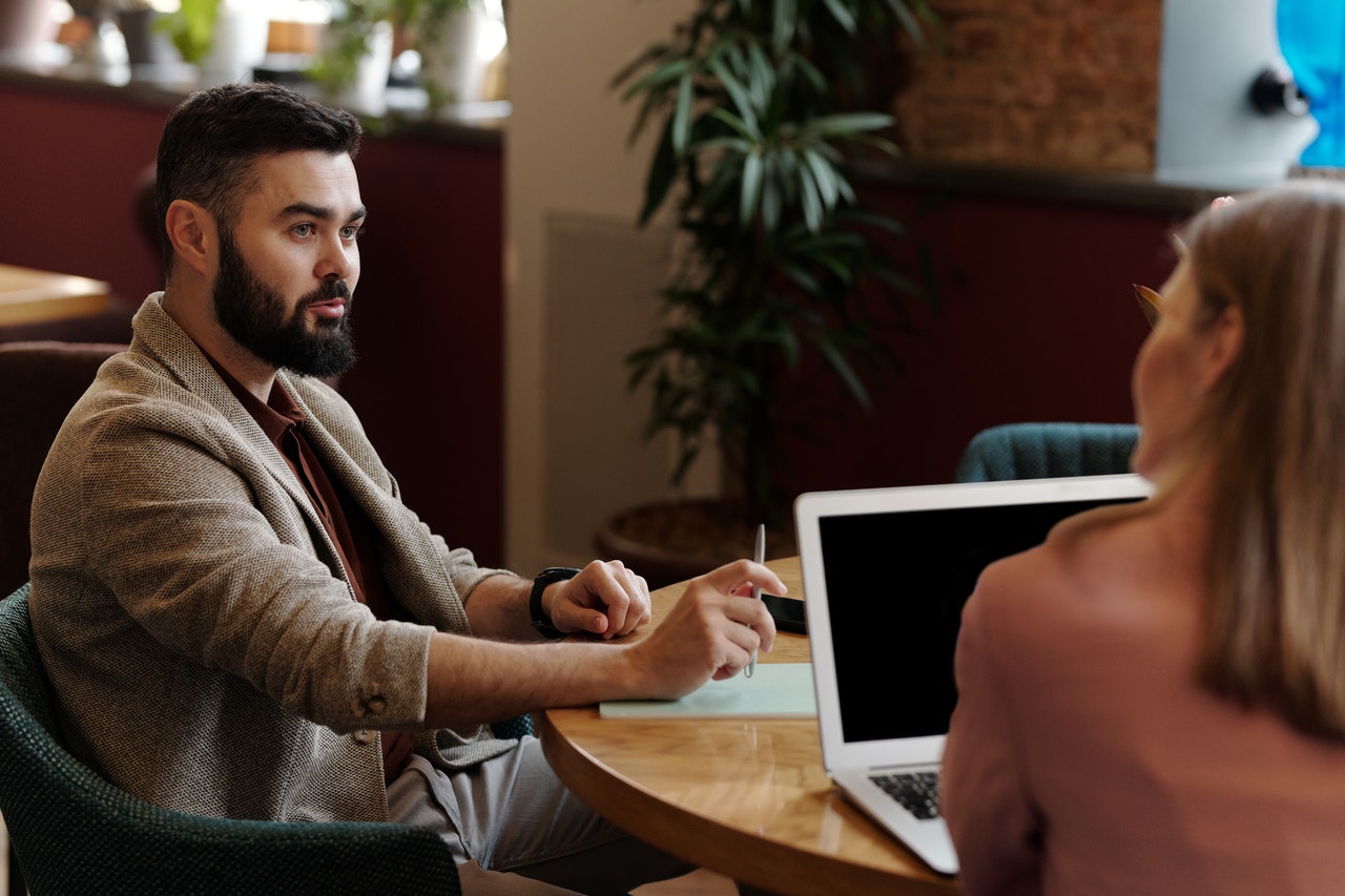 Man and woman working at a table with laptop