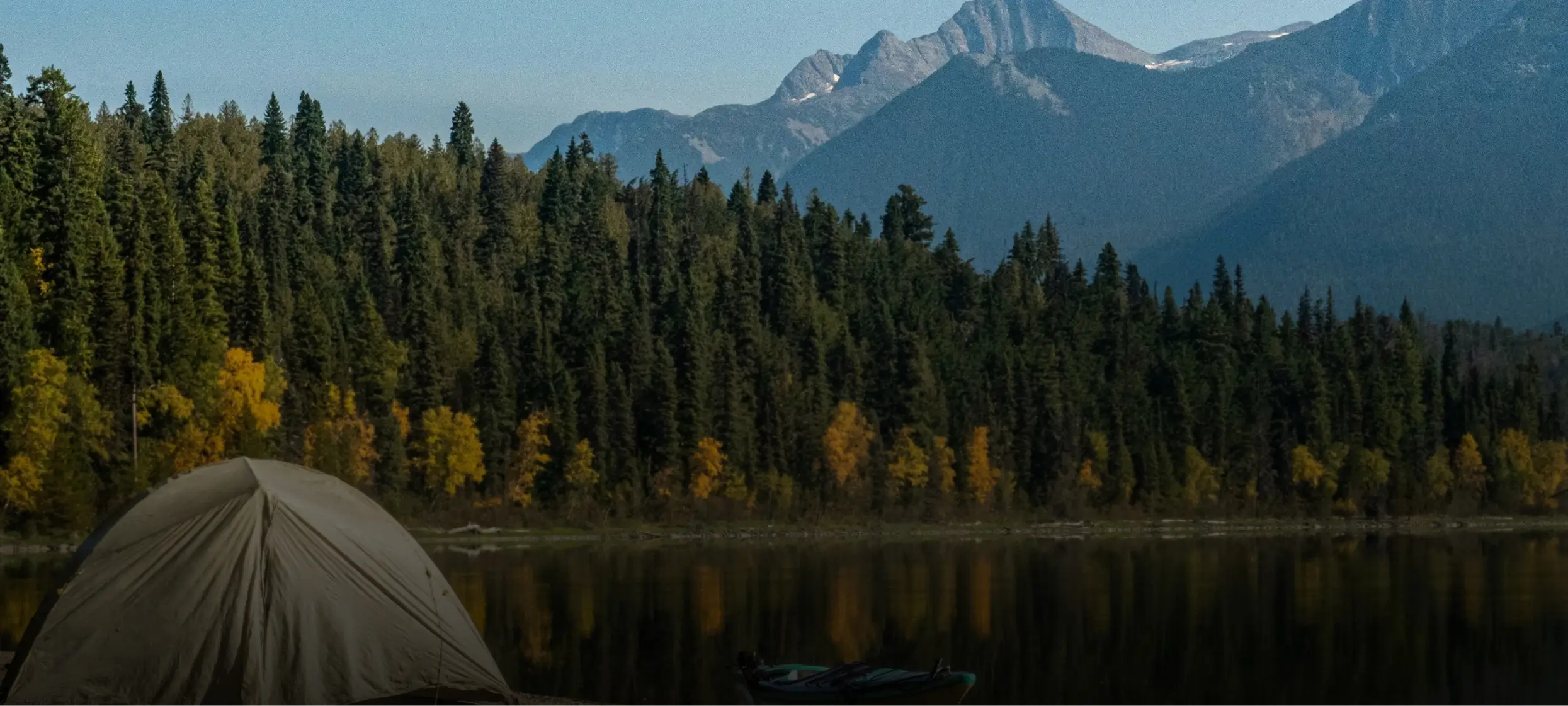 A landscape image on the mountains with a tent near a lake