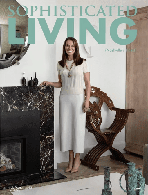 A person with short blonde hair holds a vintage camera.