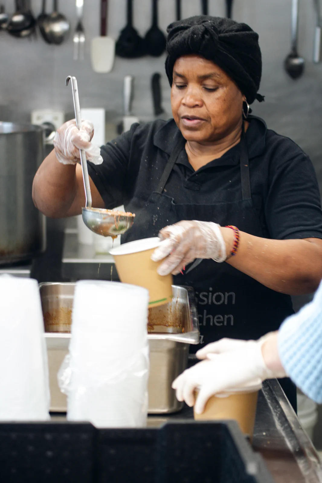 Volunteer serving soup in a kitchen