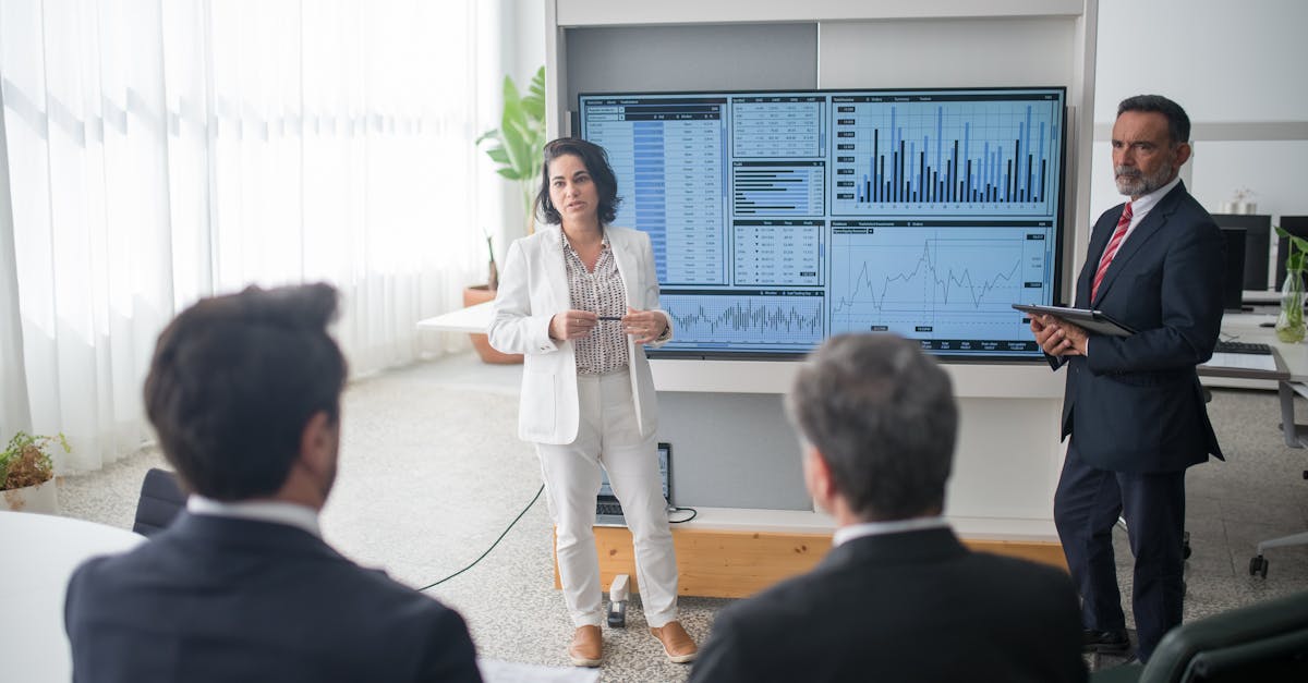 Colleagues discussing financial charts during a corporate meeting in a modern office.