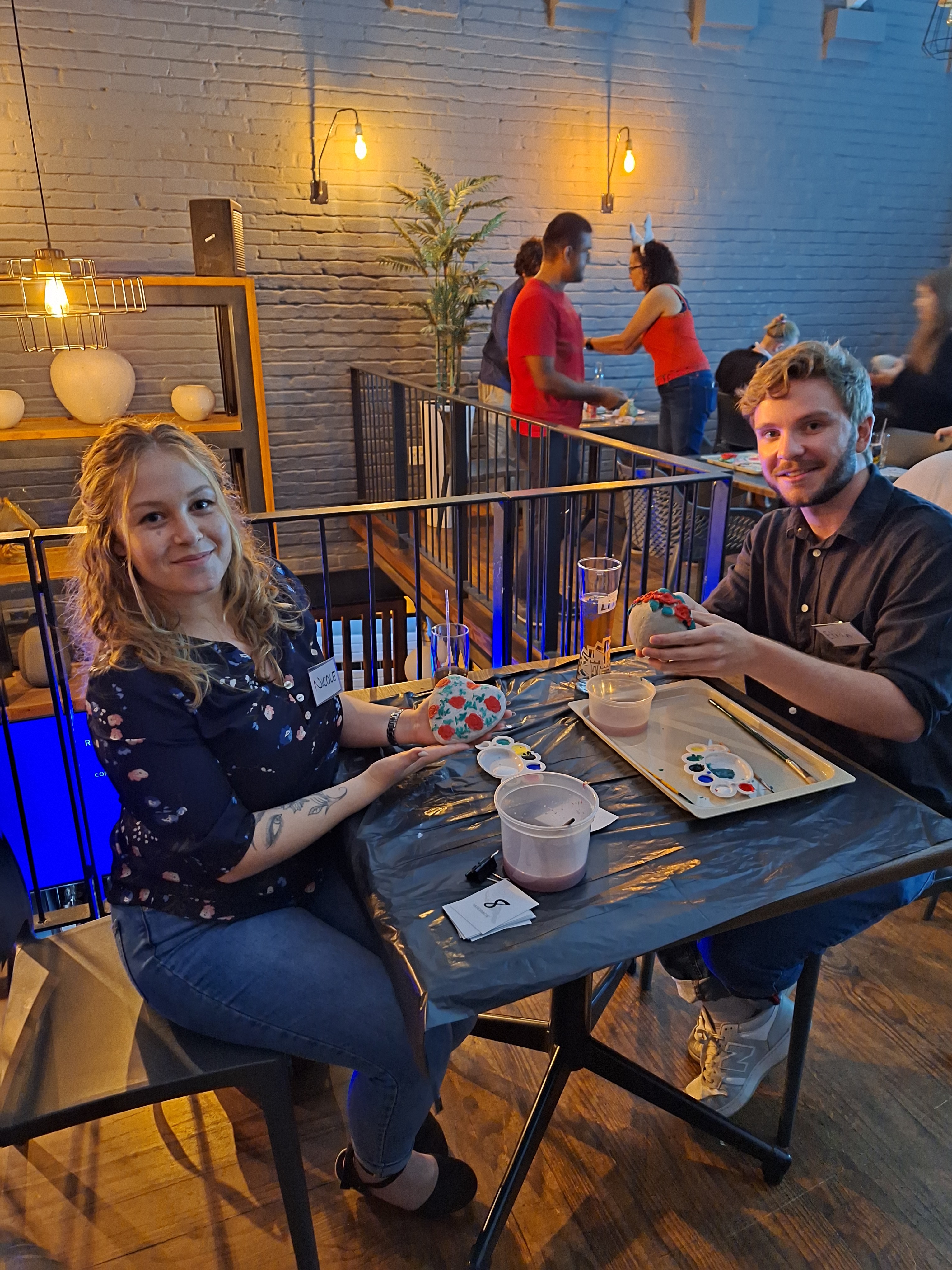 Two people smiling and showing their artwork