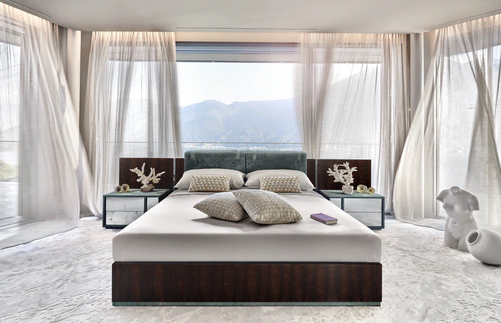 side view of a bedroom (غرف نوم فاخرة) with a contemporary selection of furniture which includes bed with wooden structure and leather inserts