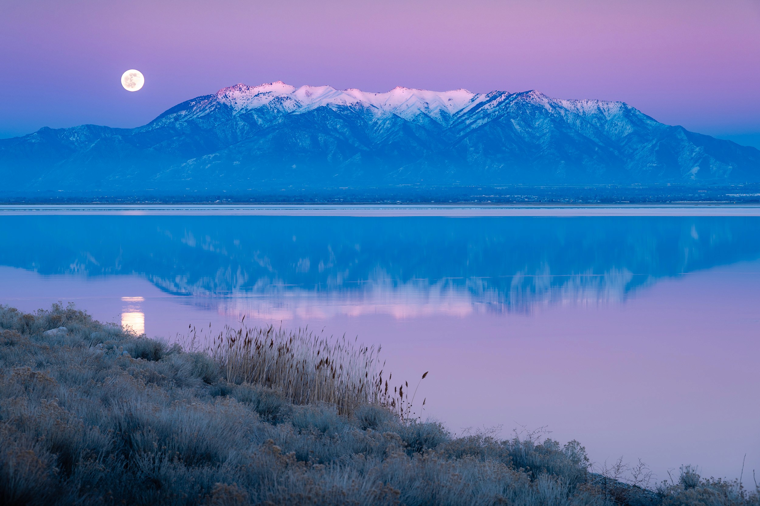 Winter sunset with the moon rising over the Wasatch Front from Antelope Island, Utah