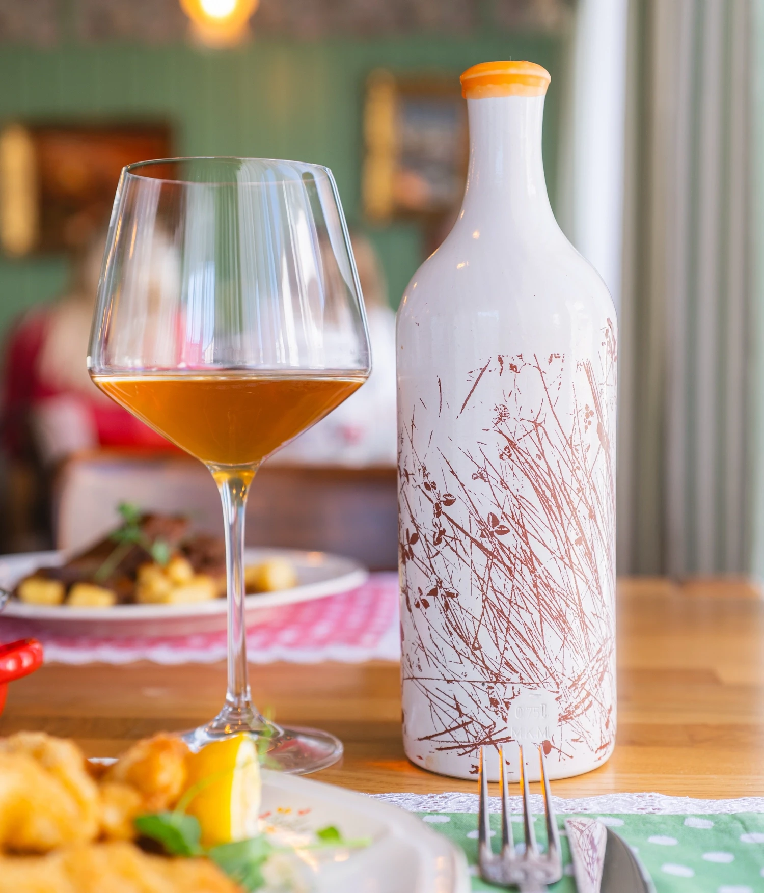 Rawino Malvazija 2022 orange vino u čaši i boca na stolu