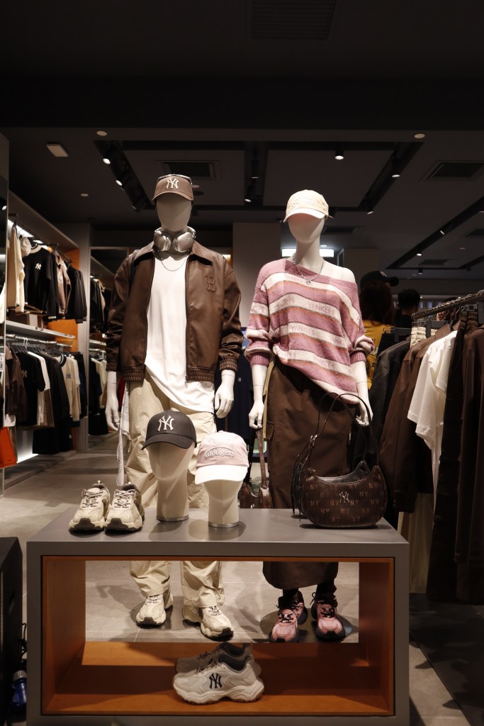Display of mannequins showcasing MLB apparel and accessories, including caps and sneakers, at the MLB 2.0 concept store.