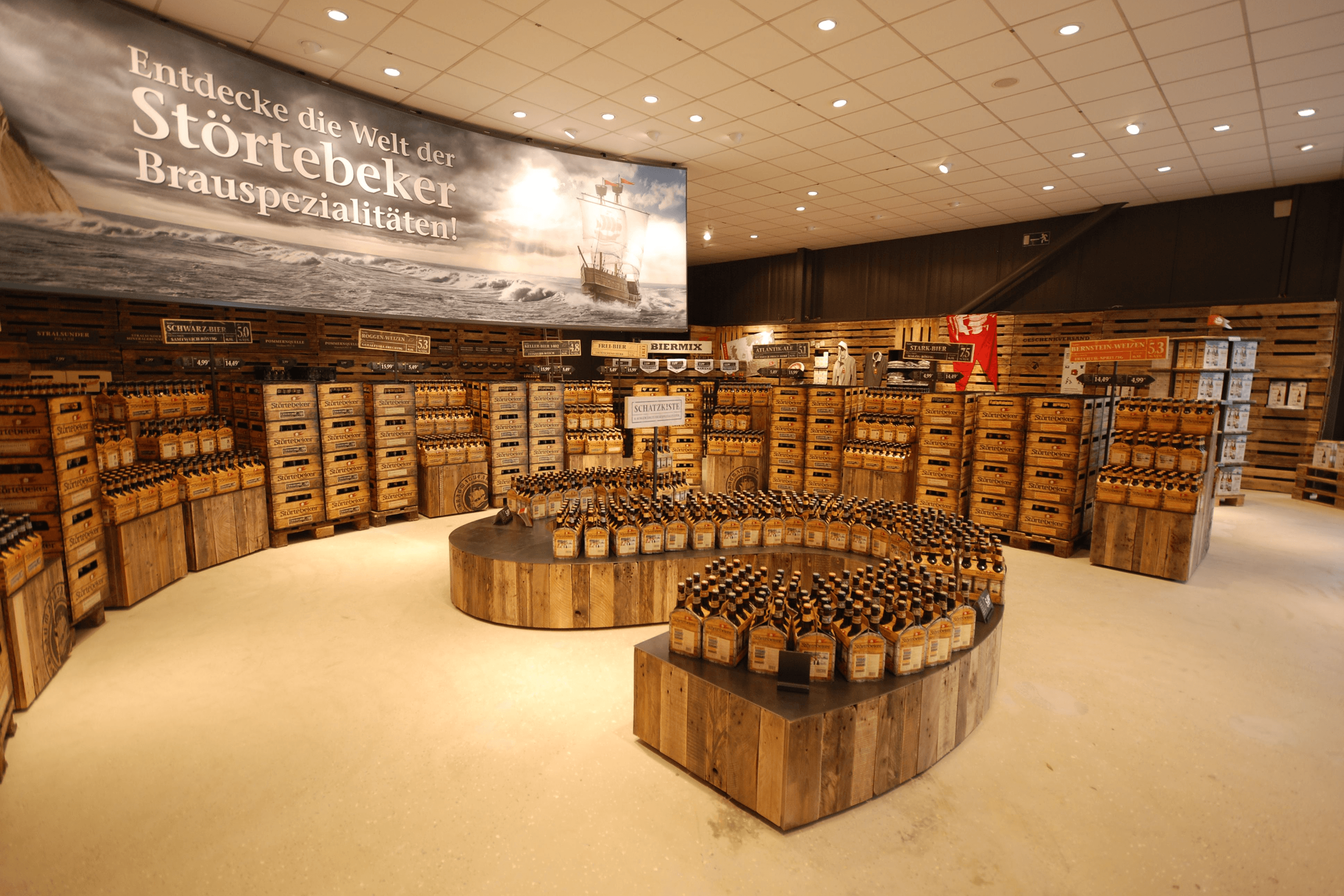 Beer bottles stacked on pallets and cylindrical displays.