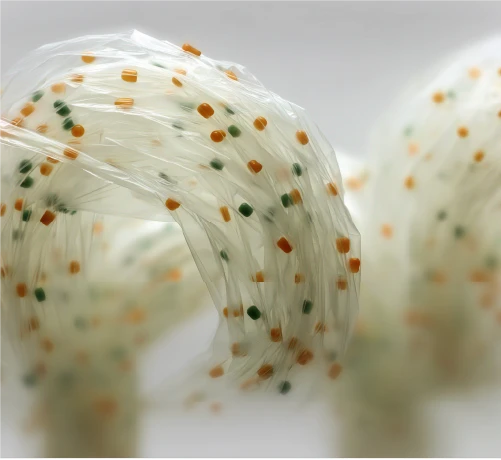 Twisted strands of Polybutylene Adipate Terephthalate (PBAT) with additive specks.