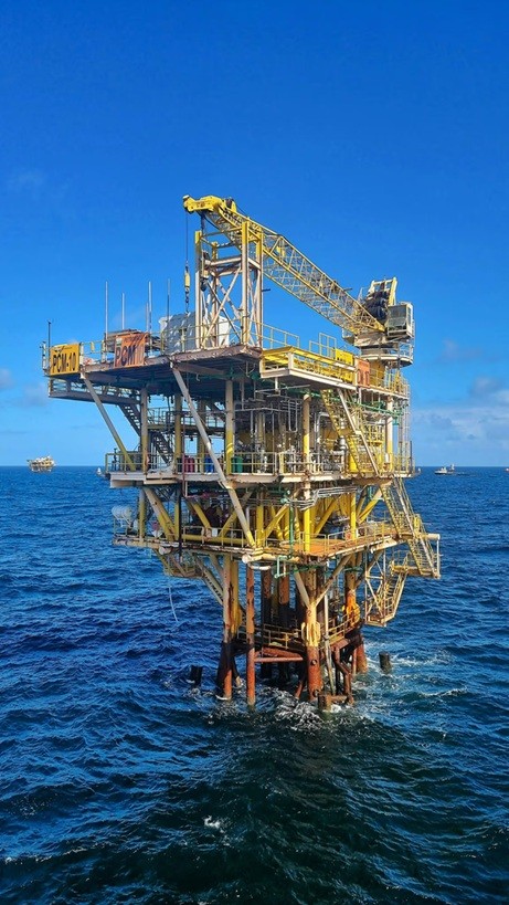 Offshore oil and gas platform standing in the open blue ocean