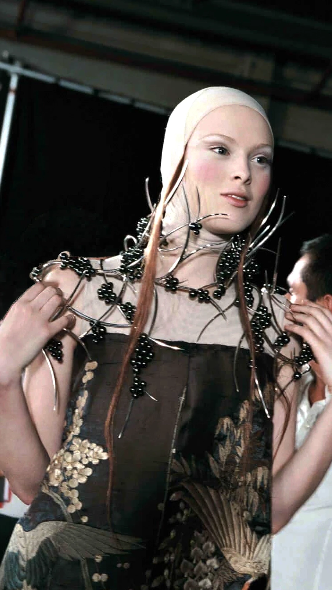 Bespoke avant-garde shoulder armour by Shaun Leane featuring silver thorns and clusters of black pearl berries, styled with a crane embroidery silk dress.
