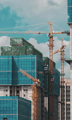 A picture of a high-rise construction site with cranes and scaffolding.