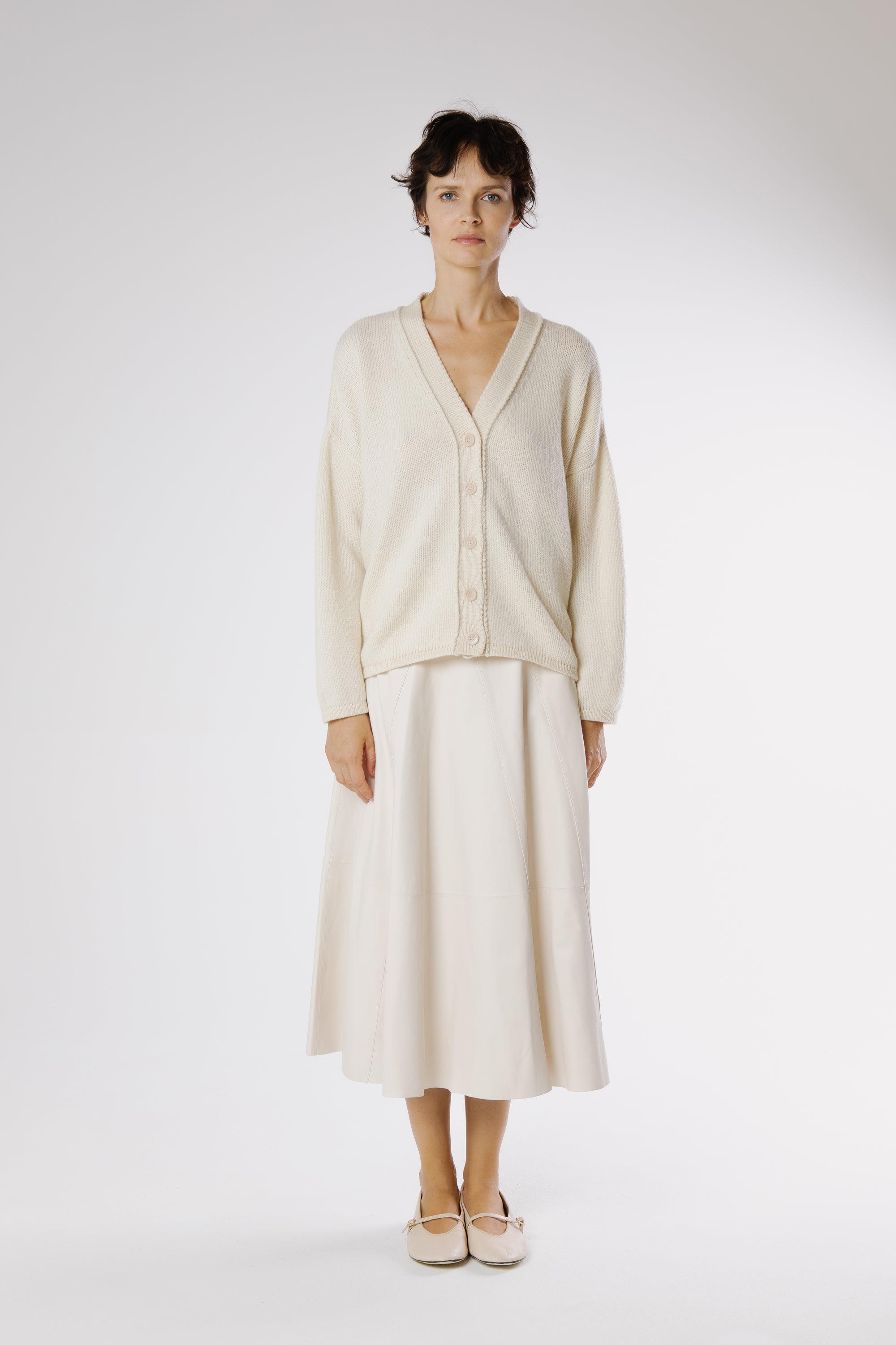 Front view of Milk-toned leather midi skirt with clean A-line silhouette and smooth panel detailing