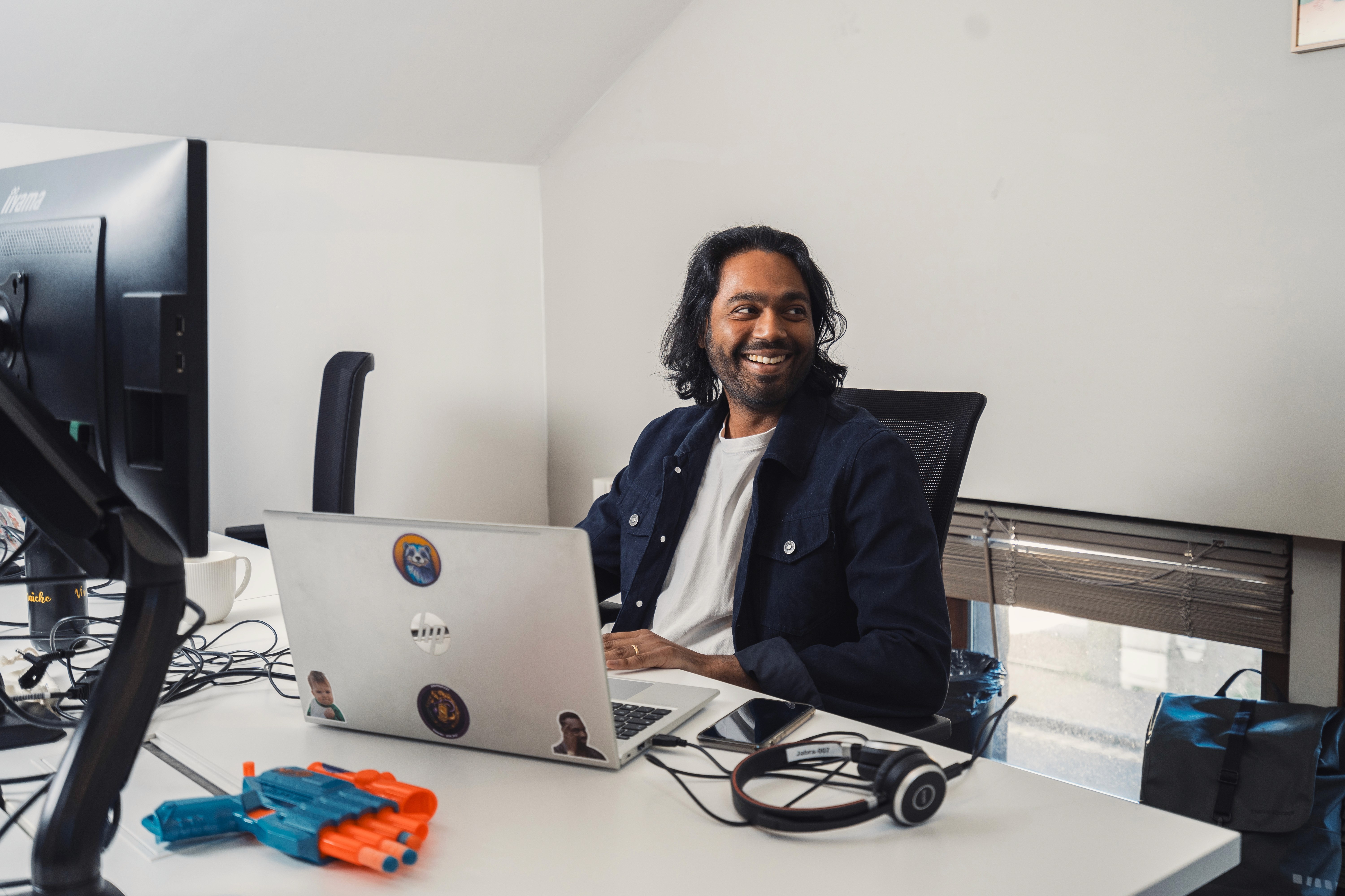 un homme en train de travailler devant son ordinateur avec le sourire