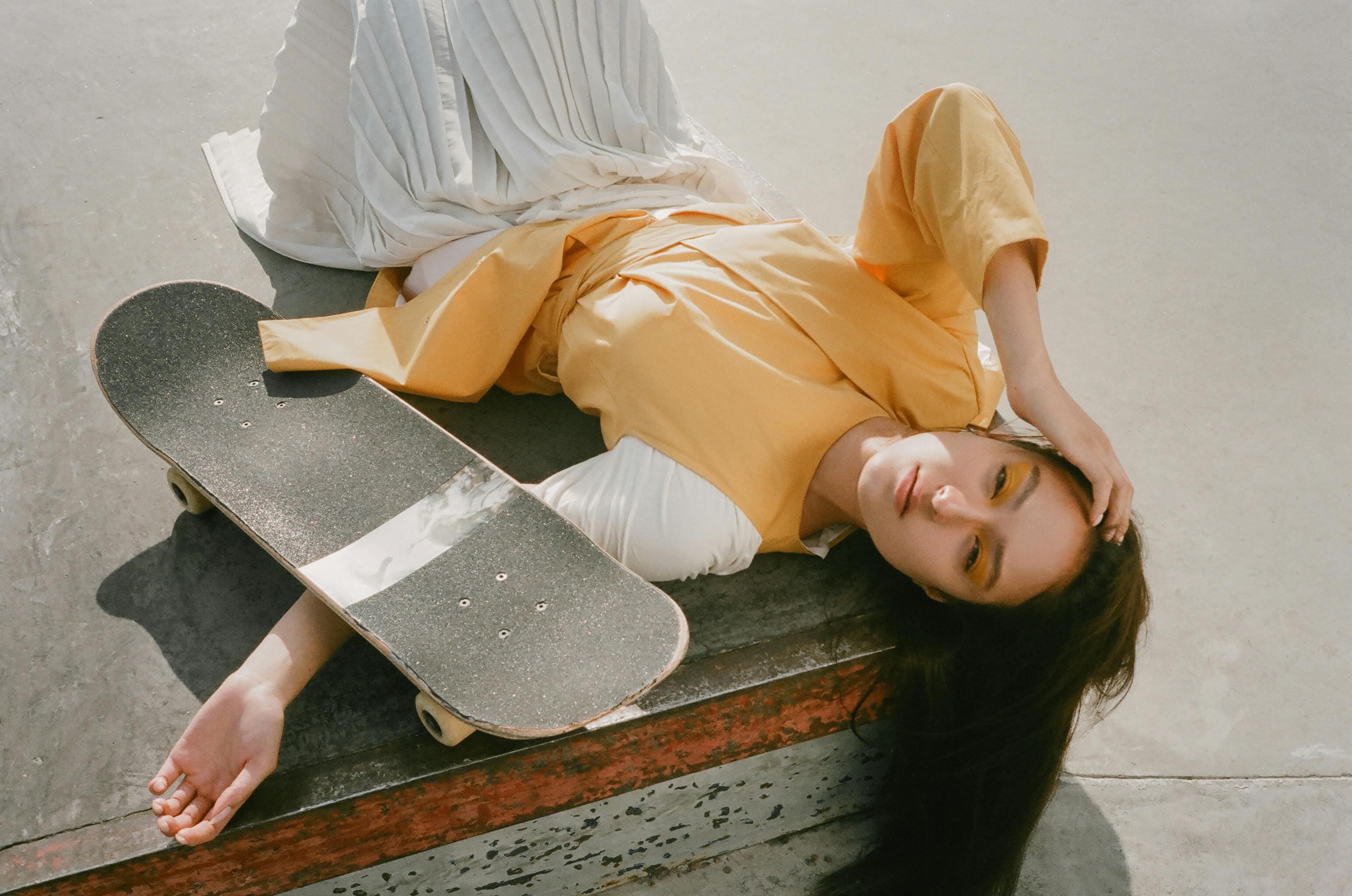 Girl lying on the ground with a skateboard