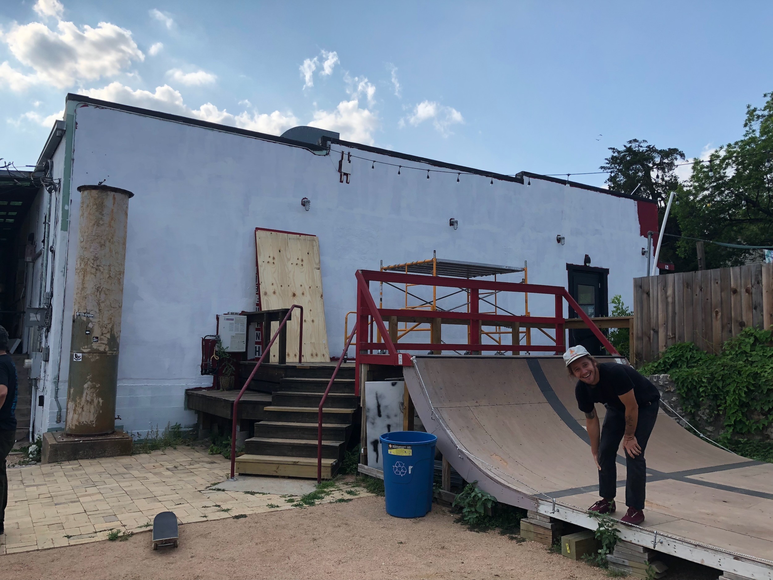 Before: a white-painted building with a skate ramp and wooden stairs in its yard.
