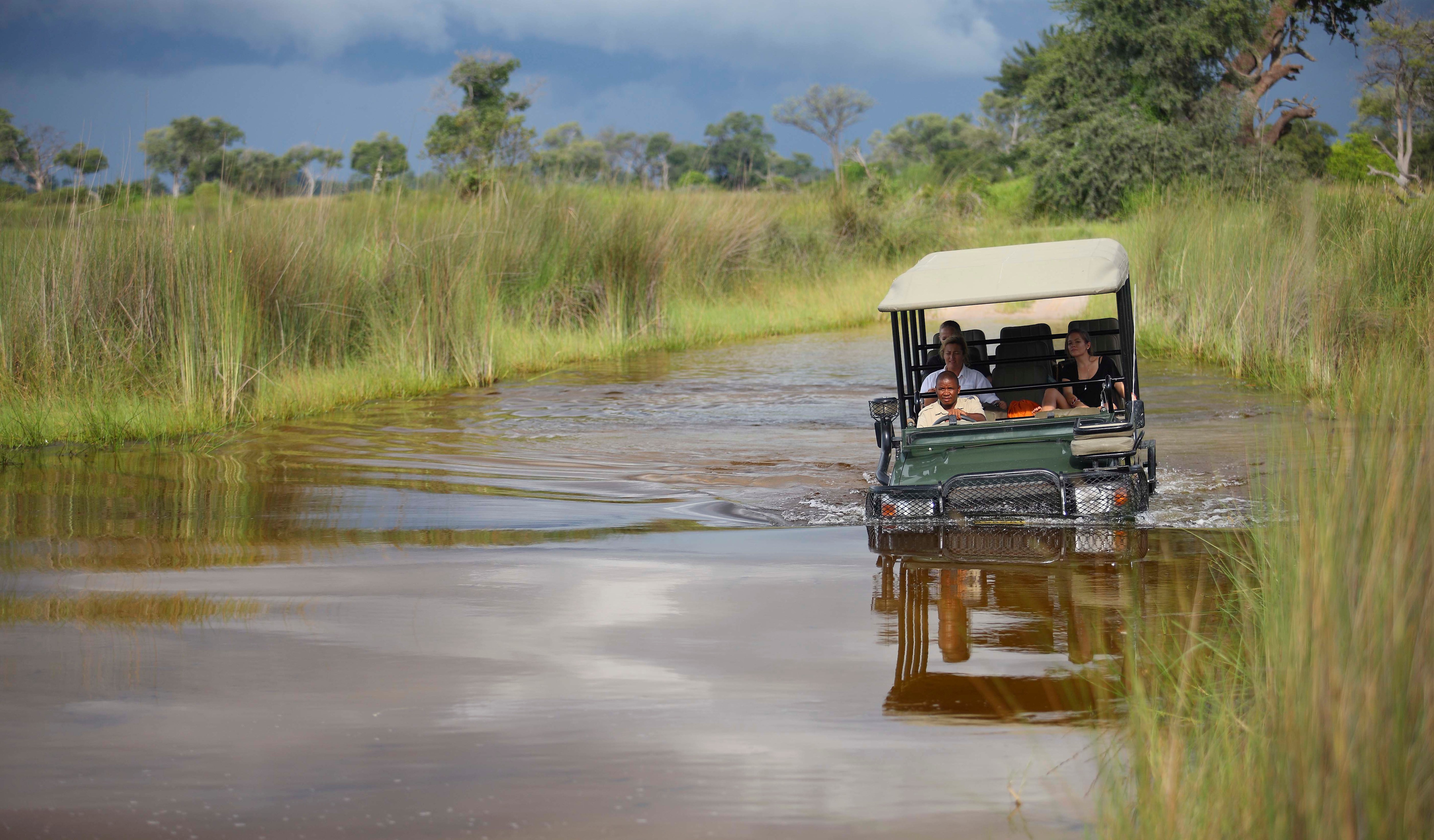 A safari vehicle crossing the Okavango Delta’s seasonal floodwaters