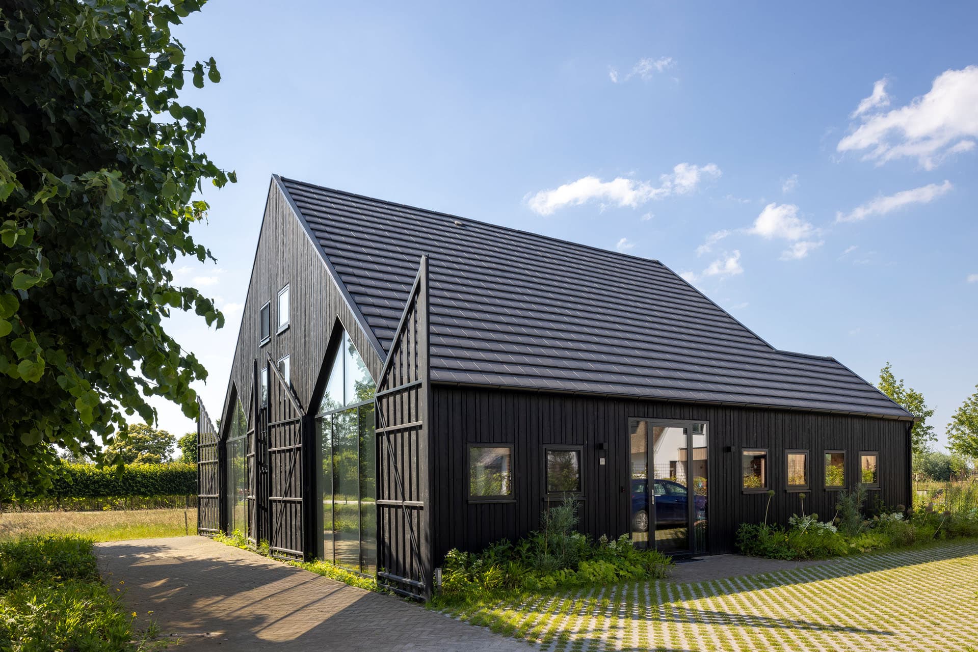 Moderne villa in Zonnehoeve Apeldoorn met lichte bakstenen gevel, grote glaspartijen en groene voortuin