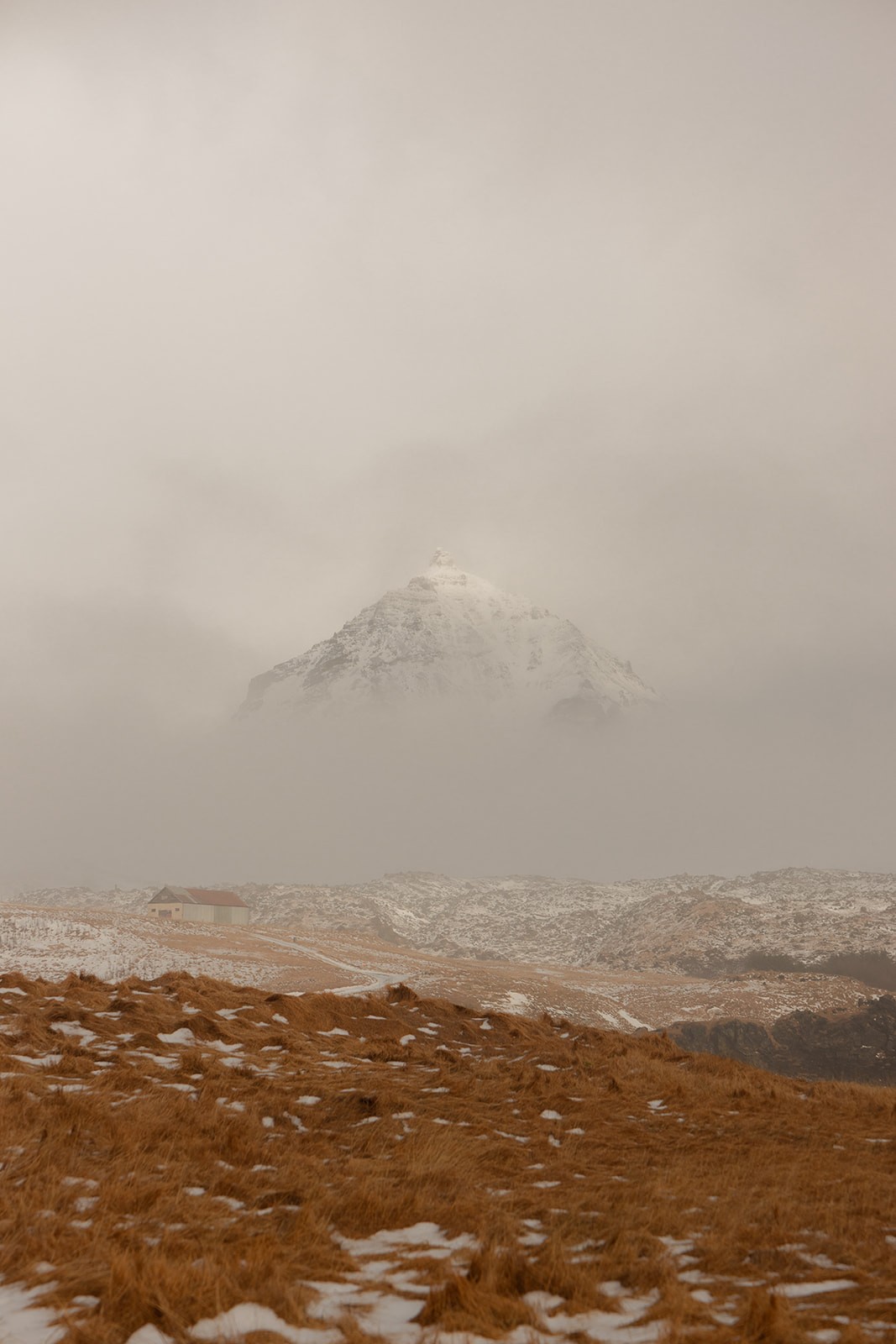 Snowy mountain in a snowy mist in a view from Peninsula Suites Iceland
