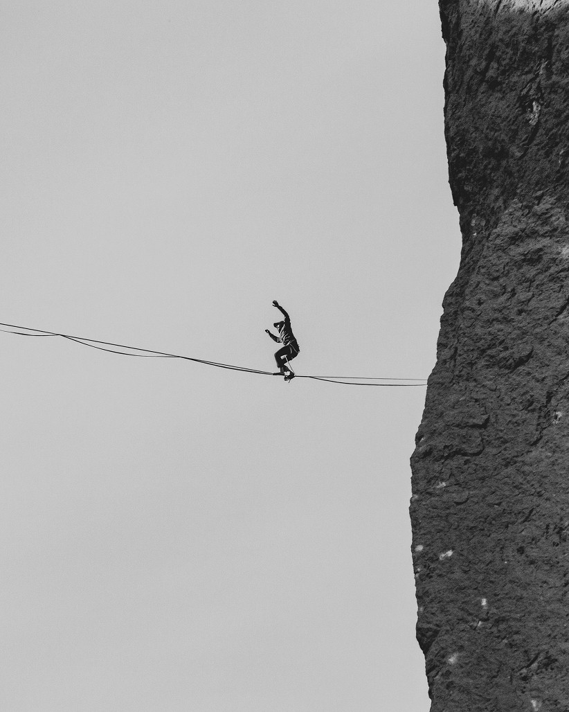 Slackline-Balancieren zwischen Felsen in großer Höhe – Training für Körperkontrolle, Fokus und Balance als Ergänzung zum Bouldern.