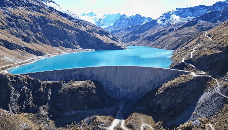 Hydroelectric dam and reservoir in the Swiss Alps, representing the role of renewable energy in supporting electromobility and sustainable transportation infrastructure in Switzerland